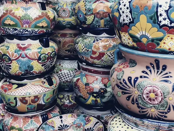 Rows of hand-painted ceramic pots in different patterns stacked for display