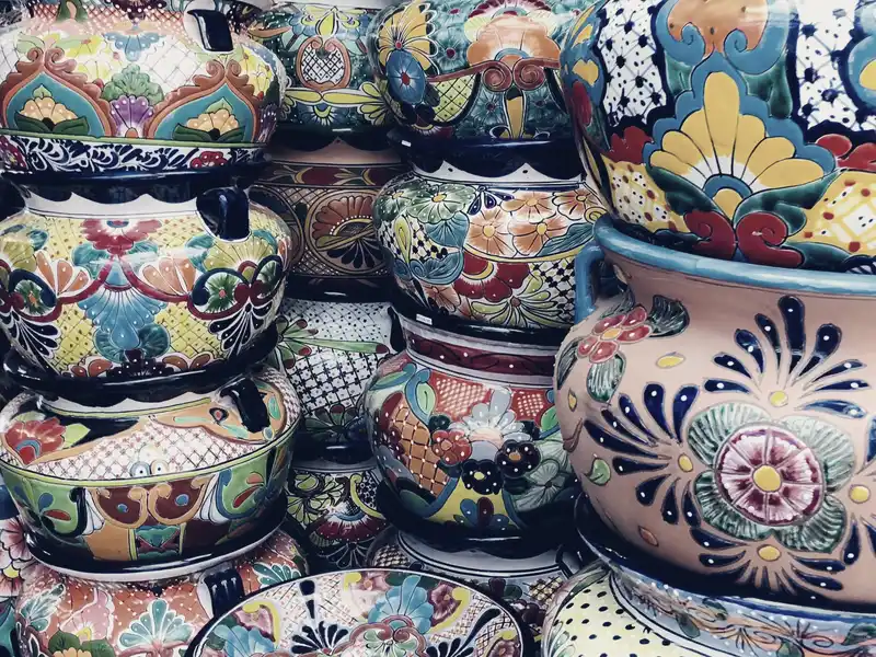Rows of hand-painted ceramic pots in different patterns stacked for display