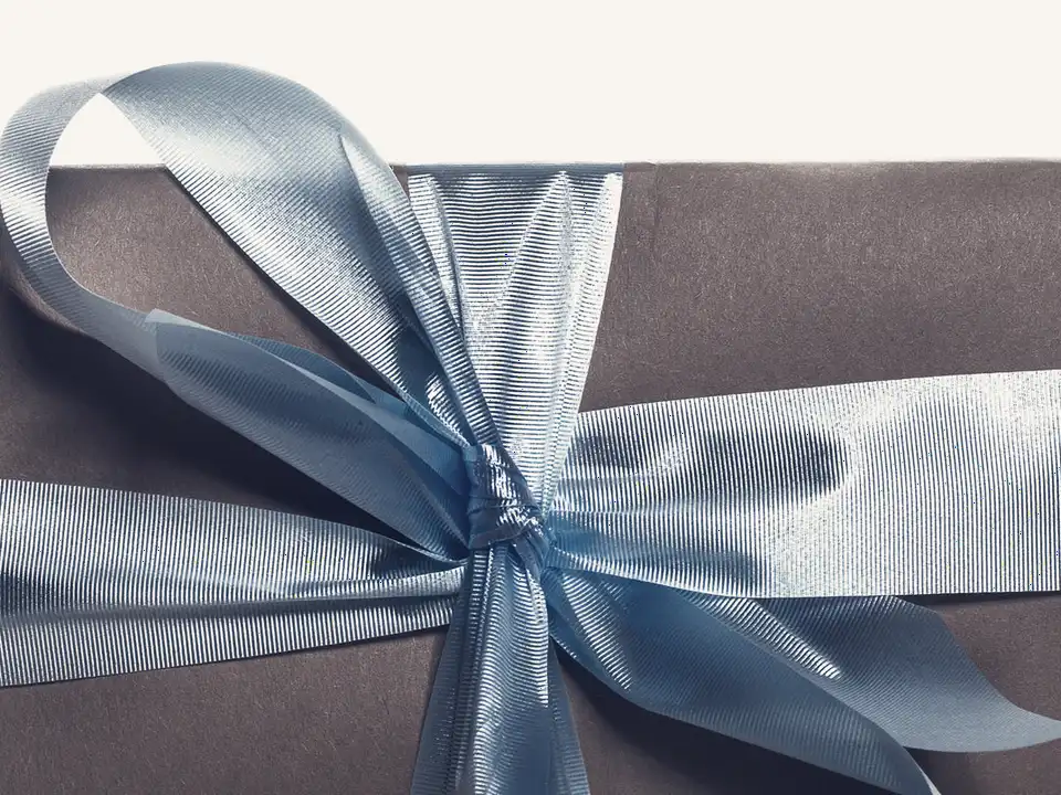 A gift wrapped in brown paper and tied with a pale blue ribbon